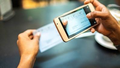 photo of a person taking a picture of a check with an iPhone