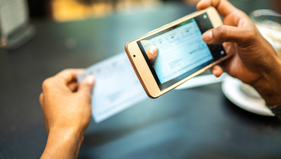 photo of a person taking a picture of a check with an iPhone